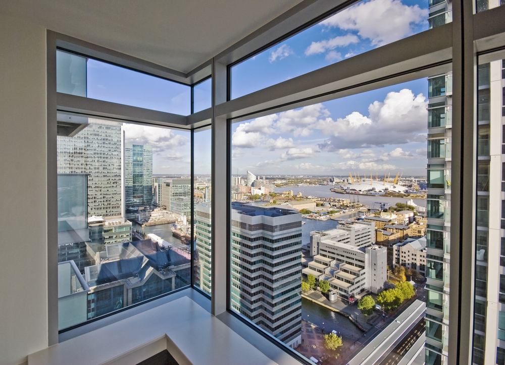 Floor to ceiling apartment window overlooking city below